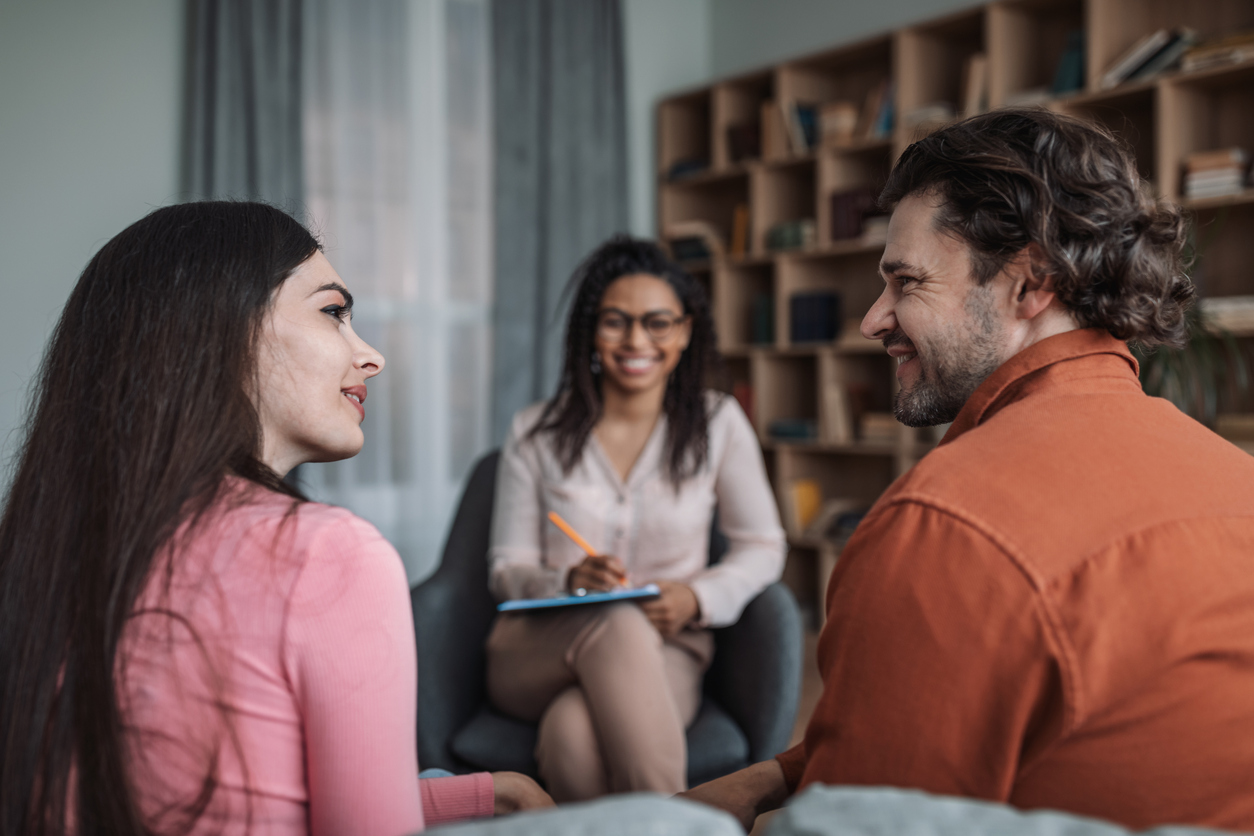 Cheerful young african american woman doctor consulting caucasian smiling couple in modern clinic Transform Your Life with Refresh Recovery & Wellness Drug Addiction Treatment in Massachusetts