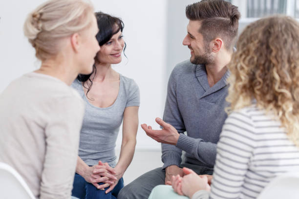 Handsome man in sweater talking to a beautiful woman during a meeting Drug Rehab Support