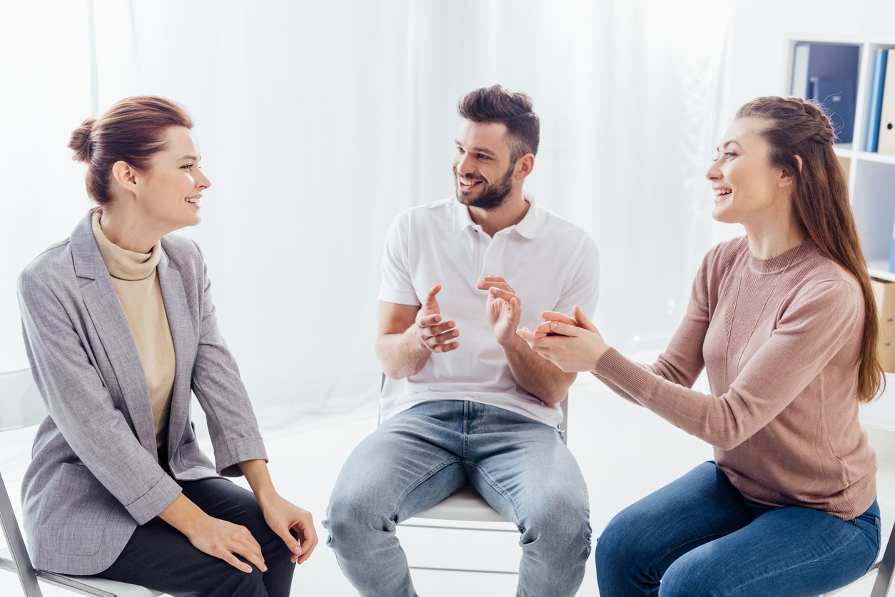 smiling women and man sitting and applauding during group therapy session Alcohol Rehab in Braintree with Refresh Recovery